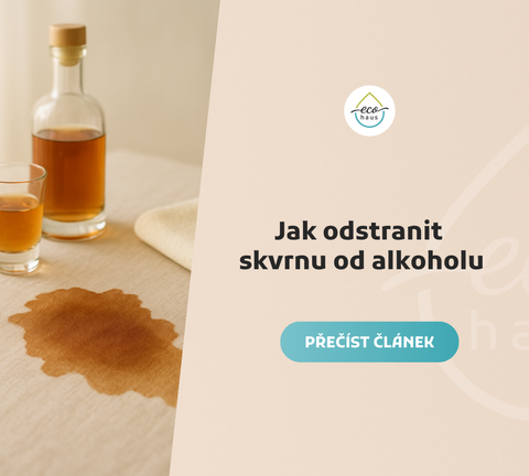 Skvrna od alkoholu na béžovém ubrusu v popředí, vedle skleničky a lahve s tmavě jantarovým nápojem