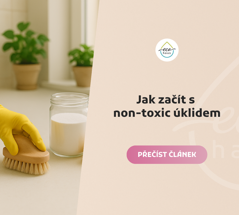 A bright, naturally lit countertop scene with a hand in a yellow cleaning glove holding a wooden scrub brush.