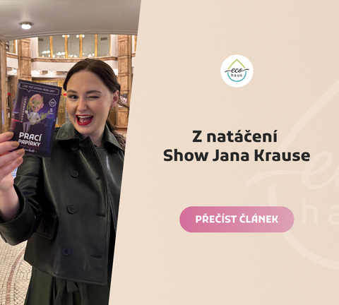 Mladá žena v koženém kabátu mrká a drží balení pracích papírků EcoHaus s nápisem ‚od teď doma peru já!‘. Pozadí tvoří interiér divadla. Vedle ní je logo EcoHaus.