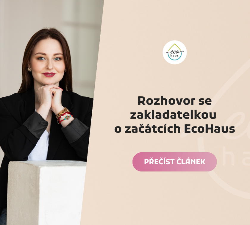Portrét mladé ženy s dlouhými hnědými vlasy opřené o ruce, oblečené v černém saku a bílé halence. 