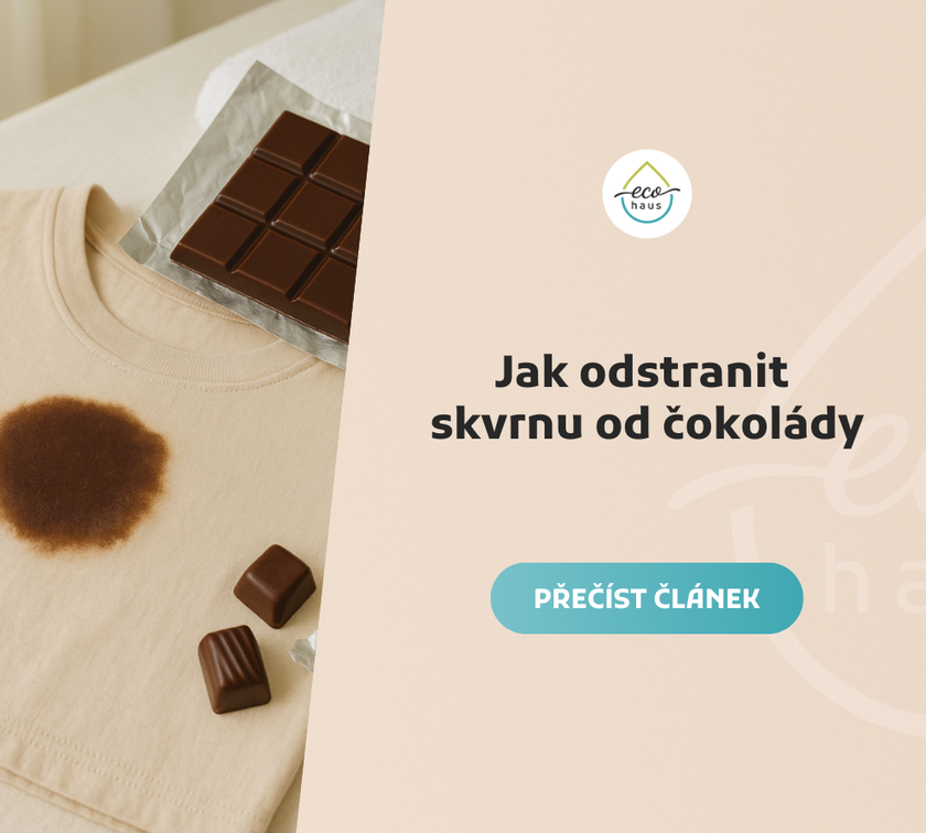 Bežové tričko s výraznou čokoládovou skvrnou na přední straně leží rozložené na světlém textilním povrchu. Vedle něj je rozbalená tabulka tmavé čokolády na stříbrné fólii, několik pralinek a pomačkané obaly.